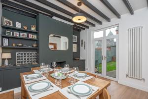 - une salle à manger avec une table en bois et des verres dans l'établissement Beautiful Redbrick Home in Ruthin Centre & Parking, à Ruthin