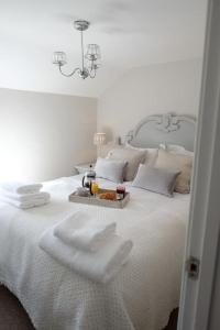 een wit bed met een dienblad met eten erop bij Cosy cottage 5 minutes walk to beach in Caister-on-Sea