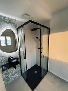 - une douche en verre dans une chambre avec un miroir dans l'établissement Sunset 8C, à Santa Pola