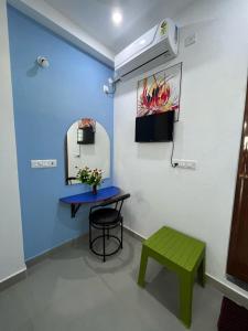 una stanza con tavolo, panca e specchio di Chez Prabha Homestay a Pondicherry
