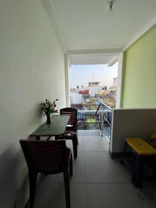 a room with a table and chairs and a balcony at Chez Prabha Homestay in Puducherry