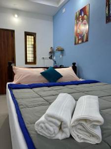 een slaapkamer met een bed met handdoeken erop bij Chez Prabha Homestay in Pondicherry