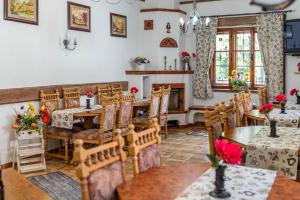 a dining room with tables and chairs and a fireplace at Penzión Aurel in Liptovský Ján
