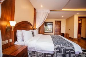 een slaapkamer met een groot bed met een houten hoofdeinde bij Kalanoga Resort in Kampala