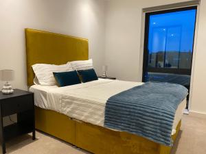 a bedroom with a large bed and a window at Triple t homes Cosy 2 bedroom Apartment with balcony in Ilford