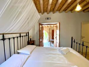 een slaapkamer met een groot bed met witte lakens bij Eveleos Country House in Tochni