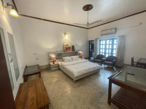 1 dormitorio con cama, mesa y sofá en BNL FARMHOUSE, en Dhanbād