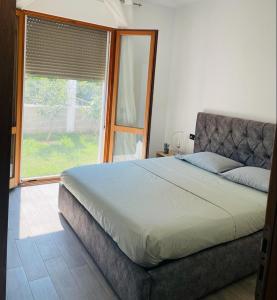 a bedroom with a bed and a large window at The quiet place in Hamallë