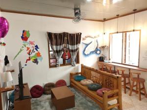 a room with a couch and a table and chairs at Ohlala Hostel in Moalboal