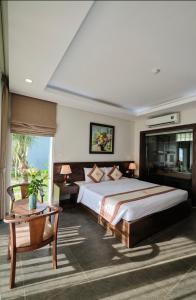 een slaapkamer met een groot bed, een tafel en een stoel bij Sea Star Resort in Dong Hoi