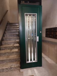 una puerta verde que conduce a una escalera con escalera en Rock n Rome - Piazza di Spagna - Via del Babuino, en Roma