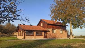 une maison en bois avec des oiseaux perchés sur le toit dans l'établissement Kuća za odmor Krolo - Blackberry Hill, à Kupinovac 26 autres photos