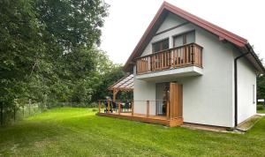 una pequeña casa con terraza en un patio en Dom całoroczny nad jeziorem Brajnickim 