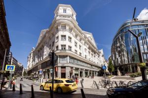 Prime Star Fashion street modern luxury apartments في بودابست: سيارة صفراء متوقفة أمام مبنى