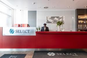 فندق سيليكت برلين جيندارمينماركت في برلين: رجل يقف عند كاونتر مطعم
