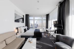 a living room with a couch and a tv at Select Hotel Berlin Gendarmenmarkt in Berlin