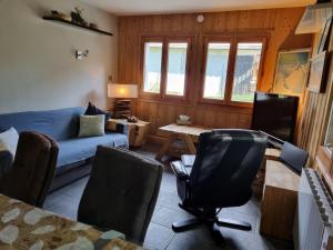 ein Wohnzimmer mit einem Sofa, einem Tisch und Stühlen in der Unterkunft A Cordon entre Bois et Nature in Cordon