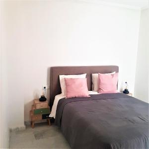 1 dormitorio con 1 cama grande con almohadas rosas en Aleksandra Apartament Sant Pere en El Campello
