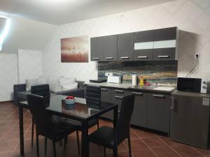 a kitchen with a table and some chairs and a counter at Anikó Szállás Baja in Baja