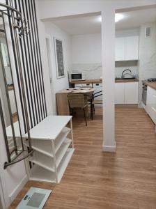 une cuisine et une salle à manger avec des armoires blanches et un escalier dans l'établissement Apartament City Center 3 bedroom, à Varsovie