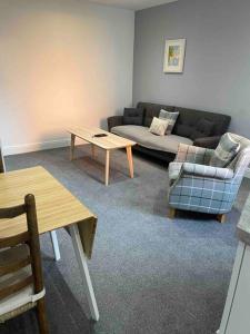 a living room with a couch and a table at Newly refurbished one bedroom apartment in Preston