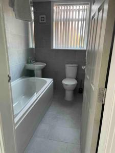 a bathroom with a tub and a toilet and a sink at Newly refurbished one bedroom apartment in Preston