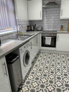a kitchen with a sink and a washing machine at Newly refurbished one bedroom apartment in Preston