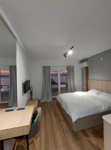 Schlafzimmer mit einem Bett, einem Schreibtisch und einem Fenster in der Unterkunft Nautica apartments&studios in Peštani