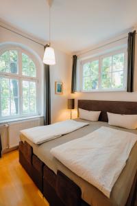 ワイマールにあるFerienwohnung am KunstTurmのベッドルーム1室(大型ベッド1台、窓2つ付)