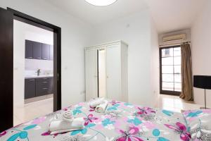 ein Schlafzimmer mit einem Bett mit Blumen darauf in der Unterkunft SLIEMA 2 Bedroom Apartment-Hosted by Sweetstay in Sliema