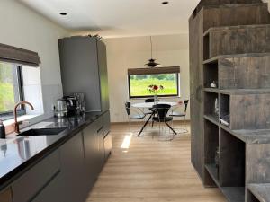a kitchen with a table and a dining room at Bij De Kei Appelscha in Appelscha +16 photos