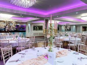 un set para una boda en un salón de baile con mesas y sillas blancas en The Terrace Hotel en Magherafelt