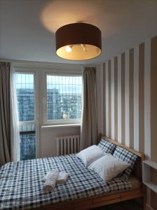 - une chambre avec un lit et une grande fenêtre dans l'établissement Apartament City Center 3 bedroom, à Varsovie