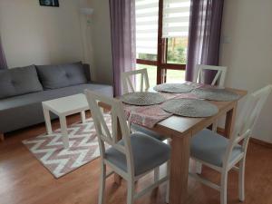 uma mesa de jantar e cadeiras numa sala de estar em Apartamenty Zdrojowe em Nałęczów