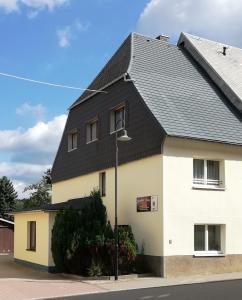 una casa blanca con techo negro en Ferienhaus Köhler en Marienberg