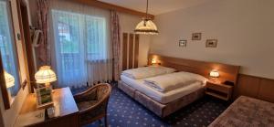 una camera d'albergo con letto e scrivania di Hotel Roy a Malga Ciapela