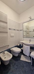 La salle de bains est pourvue de 2 lavabos, de toilettes et d'un miroir. dans l'établissement Hotel Roy, à Malga Ciapela