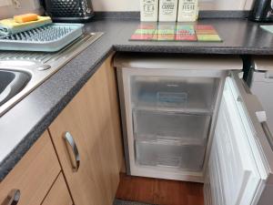 un frigorifero vuoto in una cucina accanto a un lavandino di 95 Holiday Resort Unity 3 bed passes included a Brean