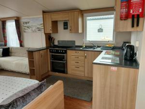 a small kitchen with a stove and a couch at 95 Holiday Resort Unity 3 bed passes included in Brean