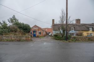 an empty parking lot in a village with houses at The Woodshed, Benhall in Saxmundham