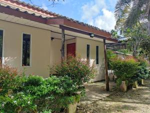 a small house with plants in front of it at Baan Suan Tondin 