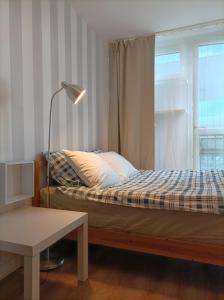 - une chambre avec un lit doté d'une lampe et d'une fenêtre dans l'établissement Apartament City Center 3 bedroom, à Varsovie