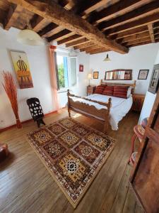 1 dormitorio con 1 cama y 1 alfombra en una habitación en L'Ancienne Forge en Villarzel-du-Razès
