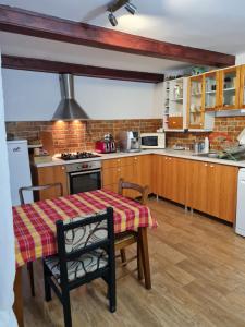 a kitchen with a table and a stove top oven at Vila Margareta in Curtea de Argeş