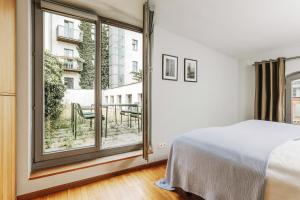 - une chambre avec un lit et une grande fenêtre dans l'établissement Josty Brauerei Appartements, à Berlin