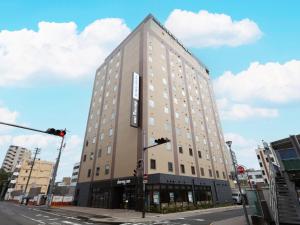 a tall building on the corner of a street at Dormy Inn Okayama Natural Hot Spring in Okayama