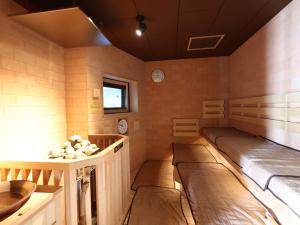 a room with two beds in the corner of a room at Dormy Inn Okayama Natural Hot Spring in Okayama