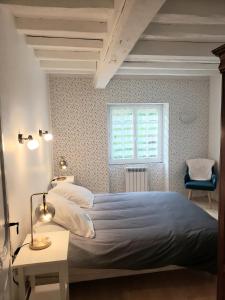 1 dormitorio con 1 cama y 1 silla azul en Appartement FONTARRABIE, en Saint-Jacques