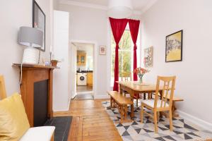 ein Wohnzimmer mit einem Tisch und Stühlen sowie eine Küche in der Unterkunft ALTIDO 3-bed Meadows flat near Castle in Edinburgh
