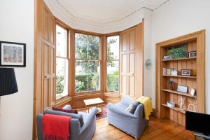 a living room with two chairs and a large window at ALTIDO 3-bed Meadows flat near Castle in Edinburgh